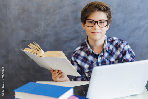 Teen boy reading book and u...
