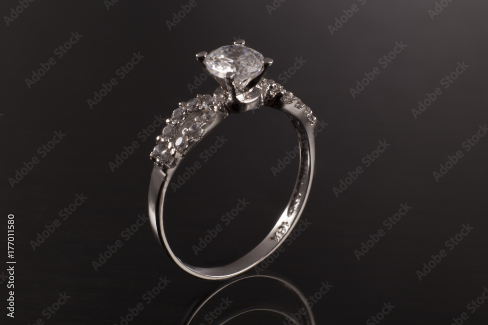 ring in gold with gemstone and diamond, classic jewelry band with gem in background black ring in gold with gemstone and diamond, classic jewelry band with gem in background black