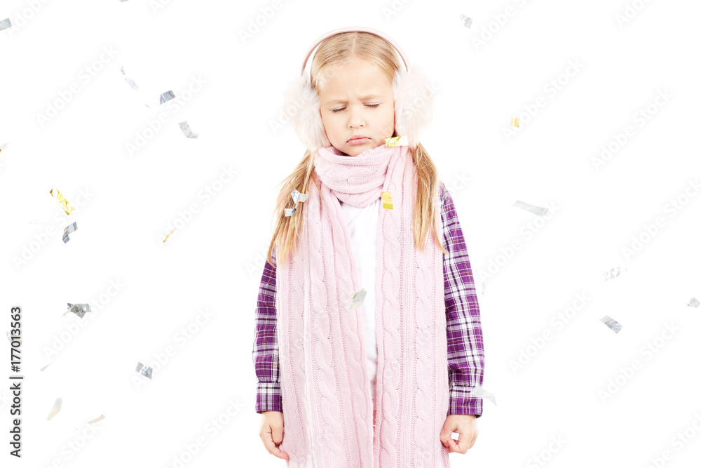 Portrait of little girl wearing scarf and winter ear muffs on white background