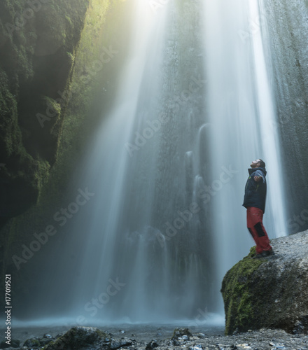 Hombre lleno de felicidad al contemplar la asombrosa cascada de Gljufrabui en Islandia