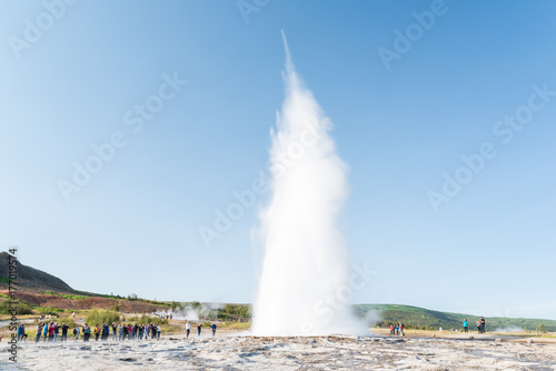 Varios personas observando la erupción del geyser Strokkur en Islandia
