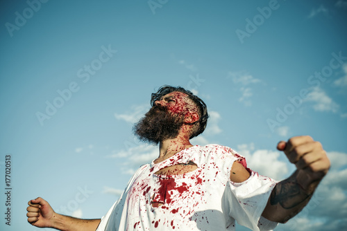 Halloween man bleeding standing with fists hands on blue sky © Volodymyr