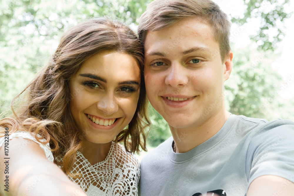 Couple of young girl and guy making selfie and smiling Couple of young girl and guy making selfie and smiling