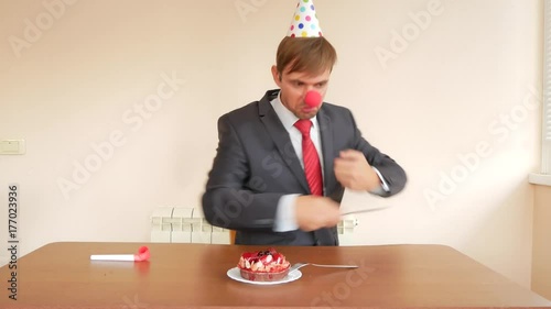 a lone man celebrates a holiday, he sits alone at a table with a cake and a candle. 4k, slow motion photo