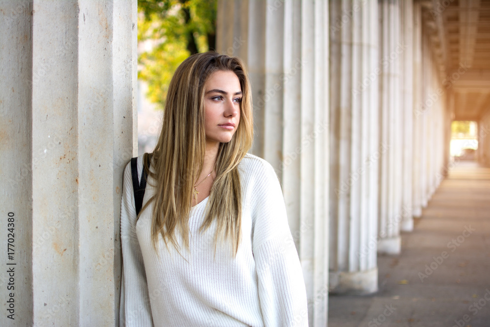 Portrait of young woman leaning on pillar. Portrait of young woman leaning on pillar.