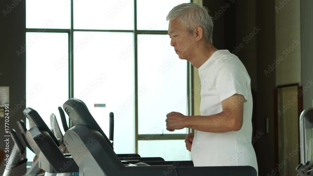 Asian senior man running on a treadmill at the gym healthy lifestyle exercise Asian senior man running on a treadmill at the gym healthy lifestyle exercise