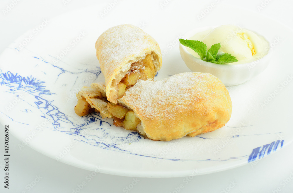 Apple strudel with ice cream decorated mint on a plate isolated on white background Apple strudel with ice cream decorated mint on a plate isolated on white background