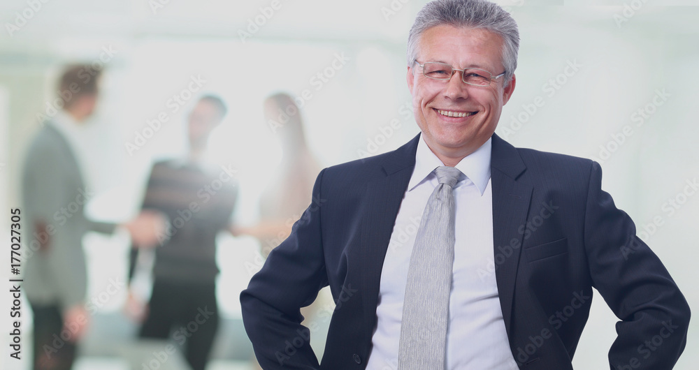 Happy mature business man looking at camera with satisfaction at office Happy mature business man looking at camera with satisfaction at office