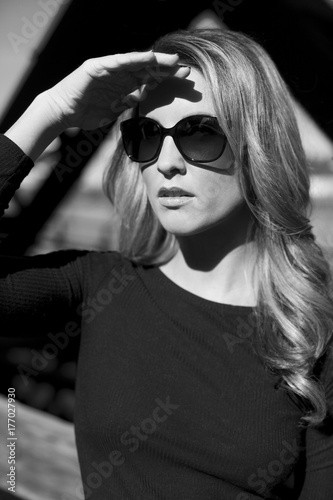 Young woman wearing sunglasses sheilding her eyes photo