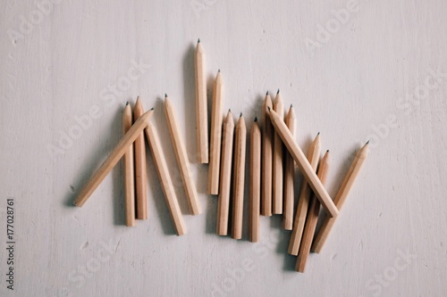 A group of small brown pencils arranged on a white table