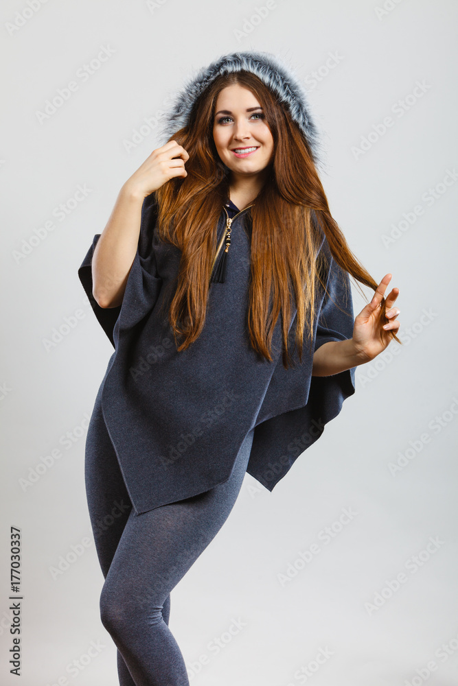 Happy woman wearing dark poncho with hood Happy woman wearing dark poncho with hood