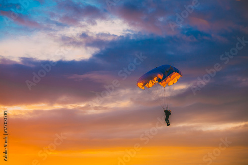 Skydiver On Colorful Parachute In Sunny Sky
