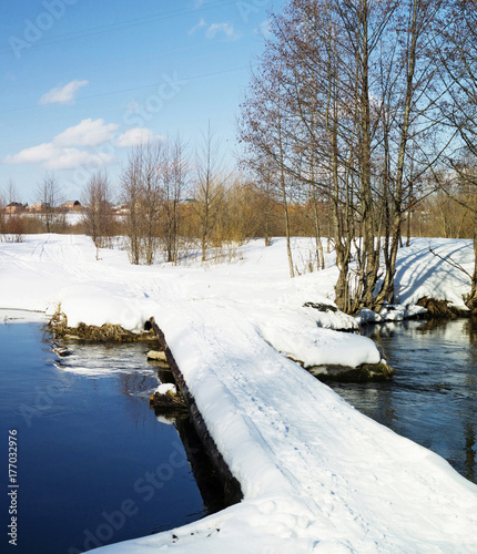 Winter landscape with bridge through stream © ovcerleonid