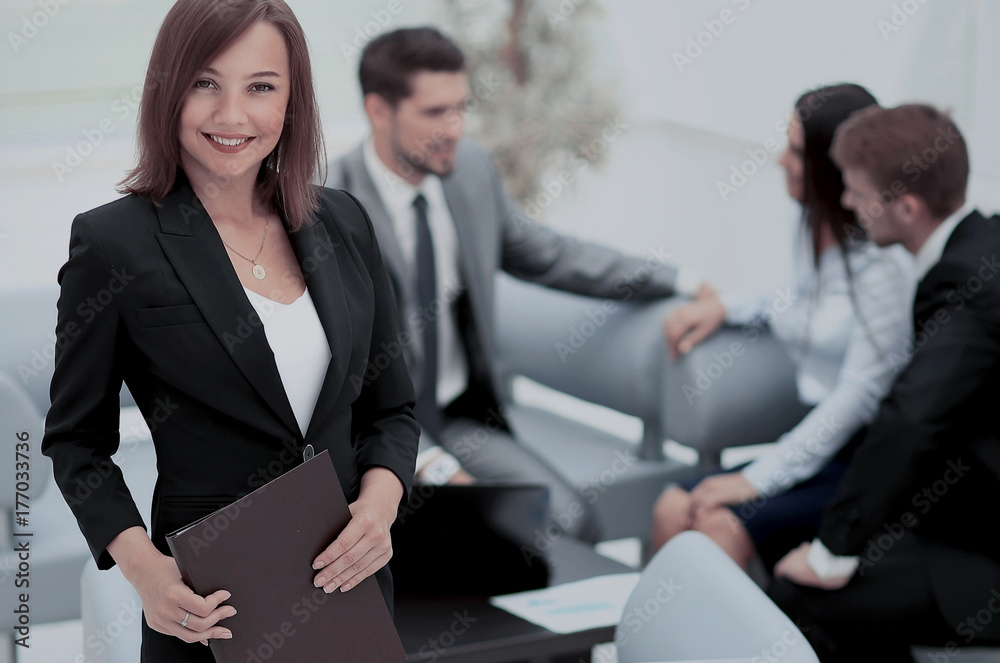Successful business woman standing with her staff in background Successful business woman standing with her staff in background