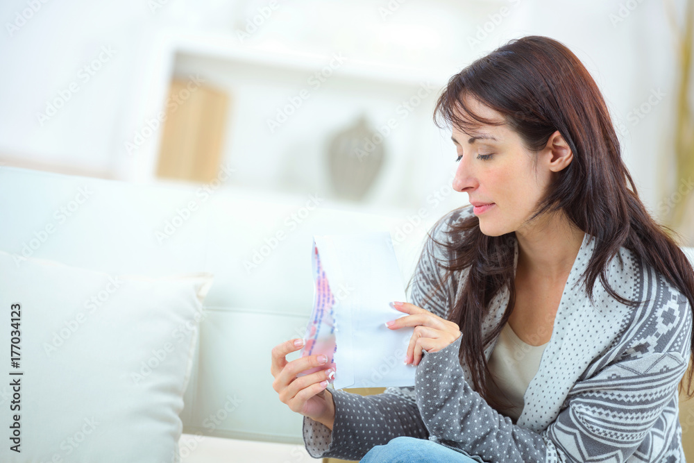 cheerful woman on sofa and holding something cheerful woman on sofa and holding something