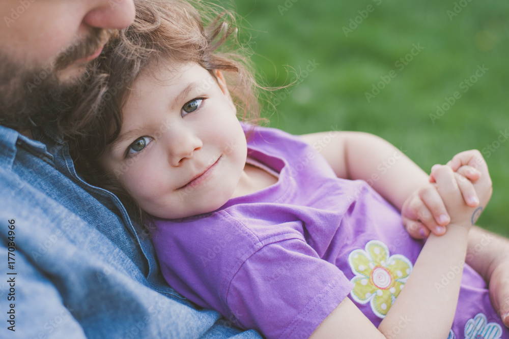 Smiling little girl sitting on his father's lap Smiling little girl sitting on his father's lap