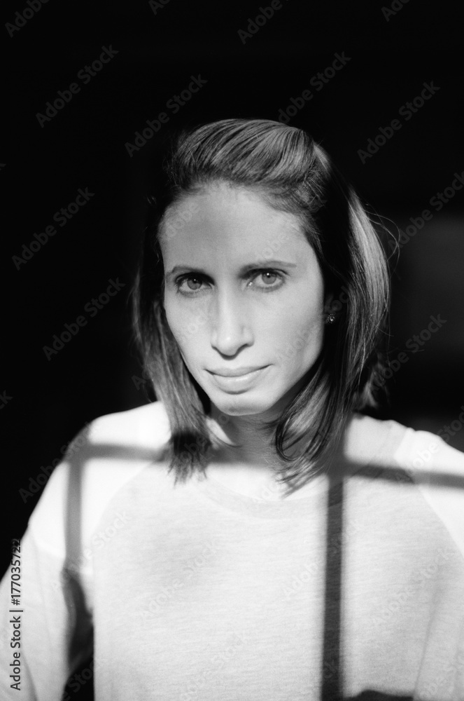 Black and white portrait of a woman with shadow from window Black and white portrait of a woman with shadow from window