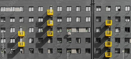 Exterior of gray residential building with yellow balcony photo