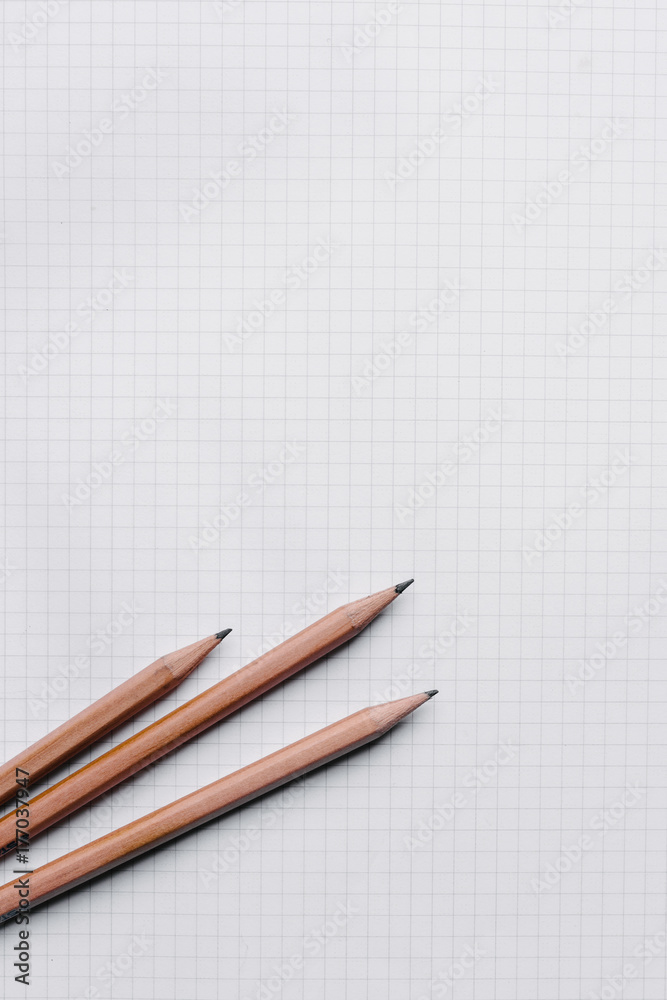 3 pencils on a white grid paper, with copyspace 3 pencils on a white grid paper, with copyspace