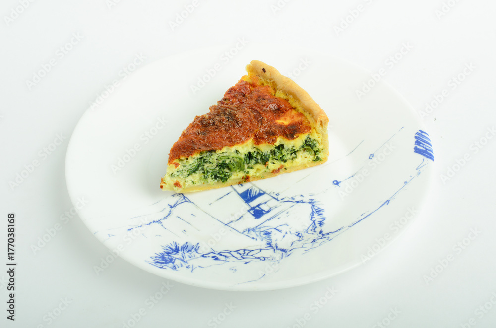 Piece of pie with spinash and cheese on plate isolated on white background Piece of pie with spinash and cheese on plate isolated on white background