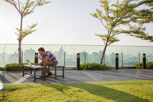 Man working on laptop outdoors