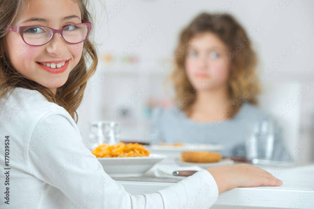 Two young sisters at the dining table Two young sisters at the dining table