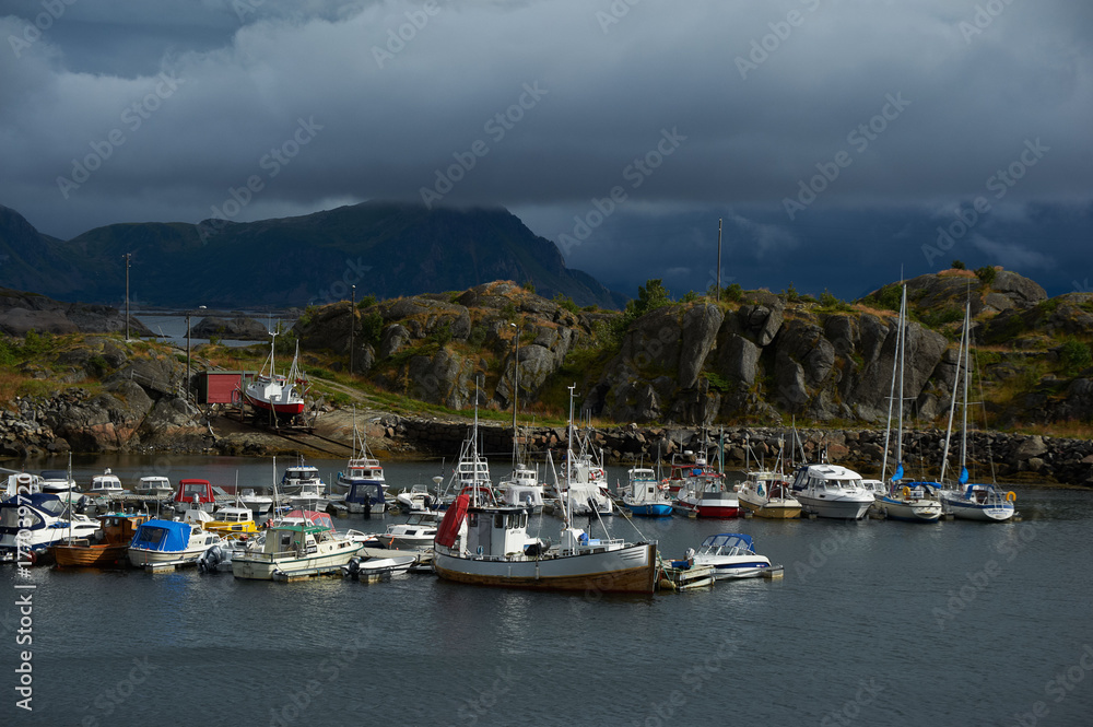 Sea gulf with boats, mountains and dark clouds