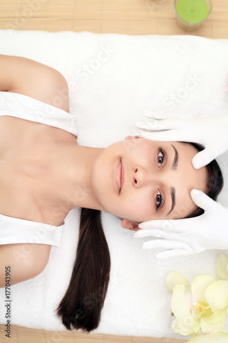 Woman under professional facial massage in beauty spa