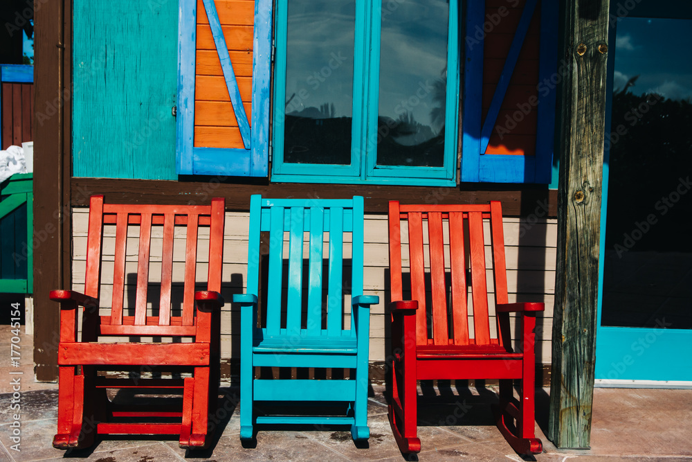 Three beach chairs outside a shack Three beach chairs outside a shack