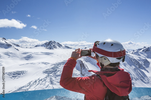 Skifahrerin macht ein Foto am Aussichtspunkt