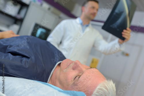 male doctor discussing x-ray with senior man in hospital