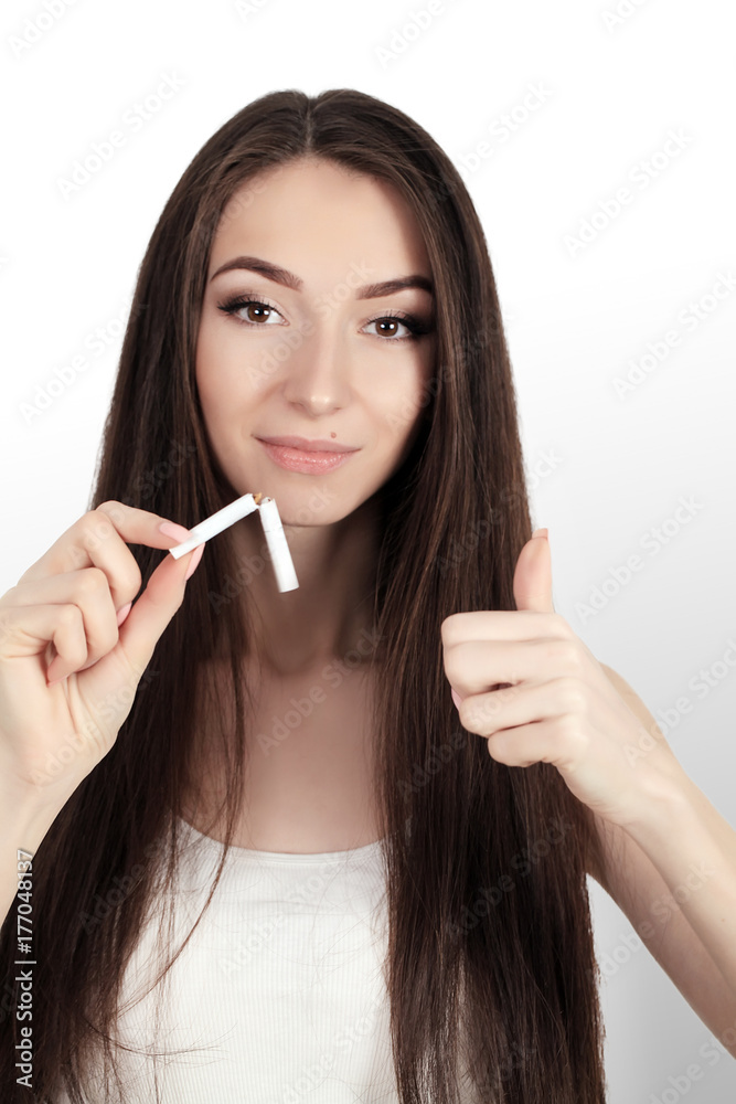 Quit Smoking. Closeup Of Beautiful Happy Female Breaking Cigarette. Portrait Of Smiling Woman Holding Broken Cigarette In Hands. Healthy Lifestyle Concept. High Resolution Quit Smoking. Closeup Of Beautiful Happy Female Breaking Cigarette. Portrait Of Smiling Woman Holding Broken Cigarette In Hands. Healthy Lifestyle Concept. High Resolution