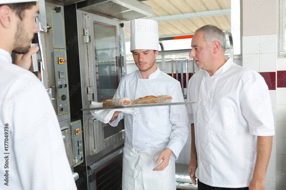 Obraz premium young chef to be putting food in the oven