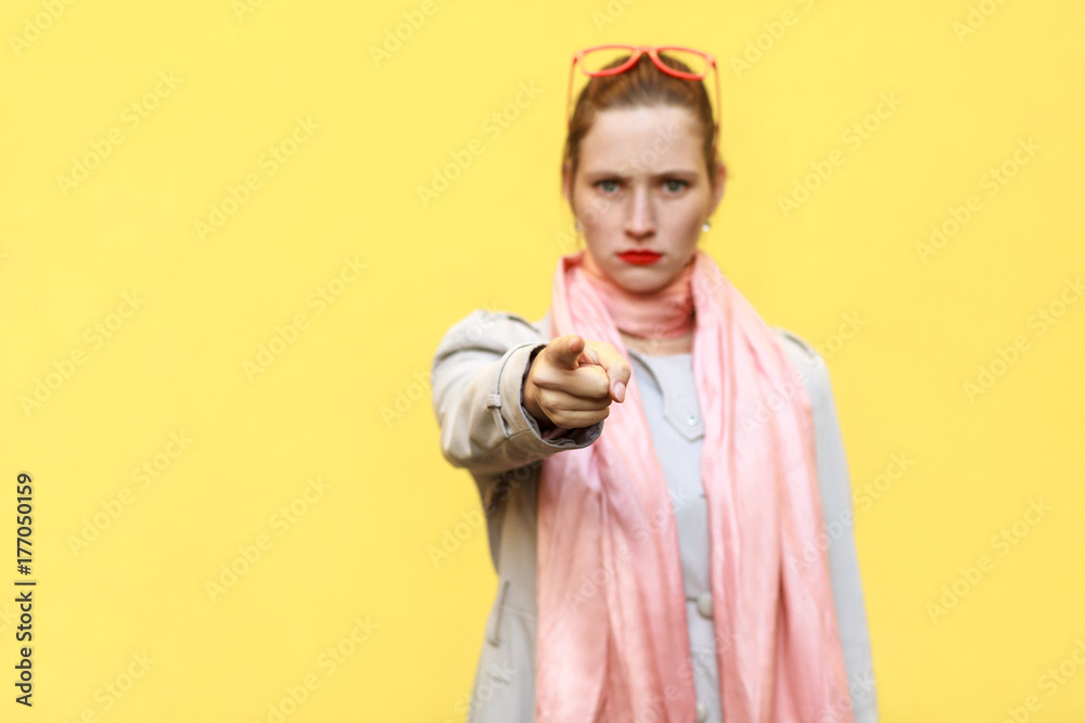 The beautiful woman, wearing autumn coat, having shocked looks, pointing finger at camera. The beautiful woman, wearing autumn coat, having shocked looks, pointing finger at camera.