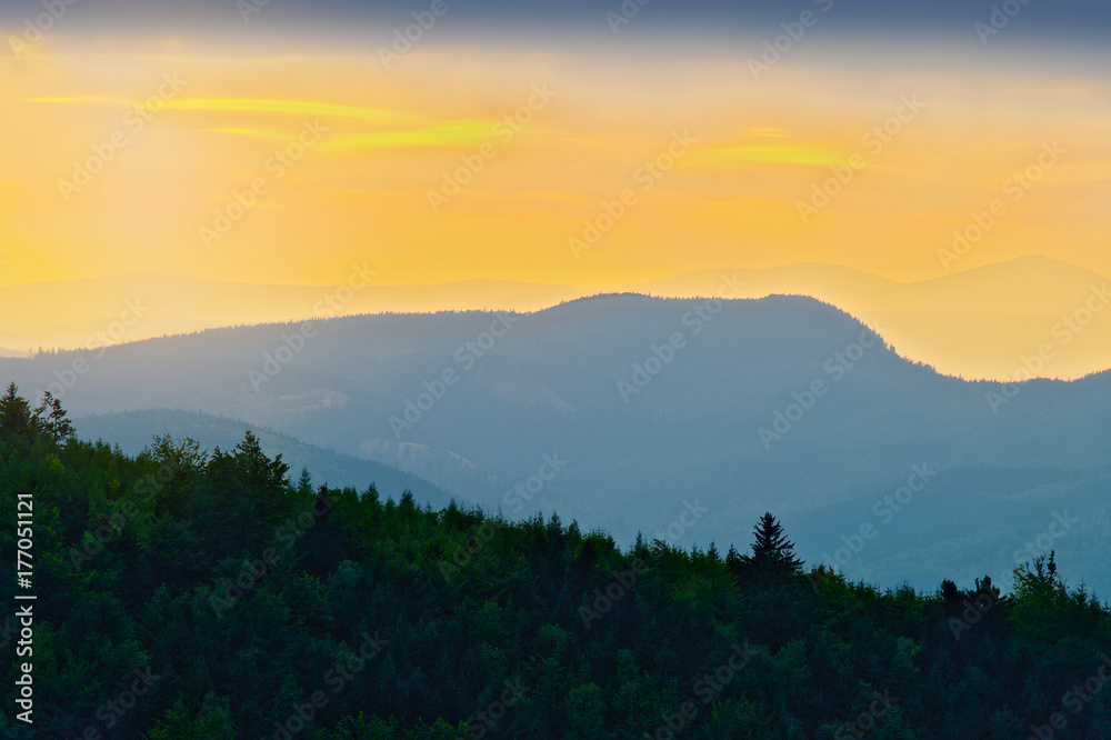 Mountain ridges layered silhouette of Sudetes range in the Owl Mountains at dusk. Owl Mountains Landscape Park, south-west Poland.