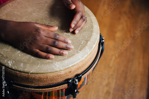 Hands of a young black girl on a djembe drum photo