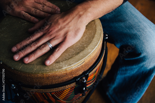 Hands of a man playing a djembe drum