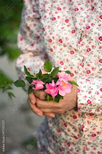 Woman holding a dog rose bouquet photo