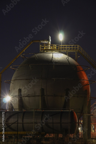 Oil refinery tank at night