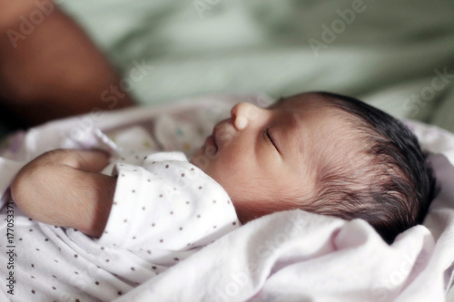 Newborn baby lying  on Bed and Wrapped In a Blanket photo