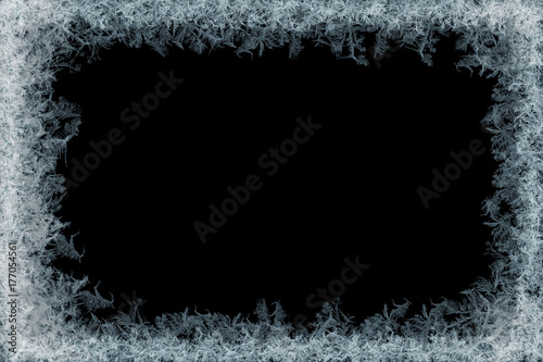 Frostwork. Decorative ice crystals frame on black matte background. 