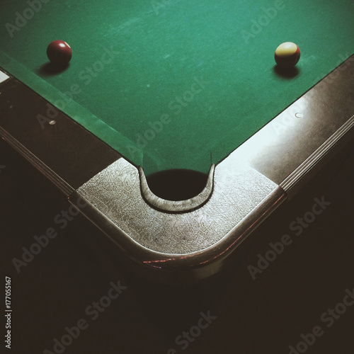 Corner of a pool table with two pool balls