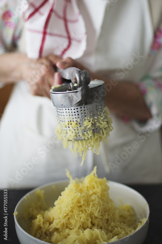 Close-up of woman hand using potato masher photo