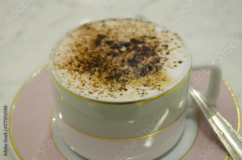 top view of hot coffee cappuccino latte art in white ceramic cup on wooden plate