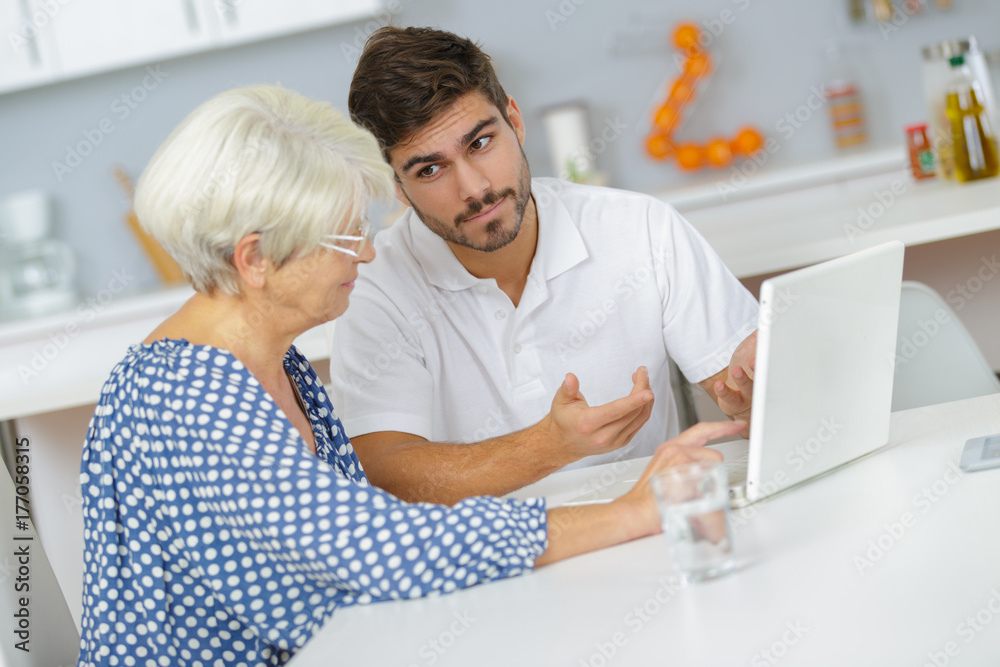 man teaching his granny to use the laptop man teaching his granny to use the laptop