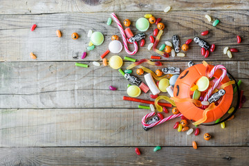 Halloween candies on wood table - background top view