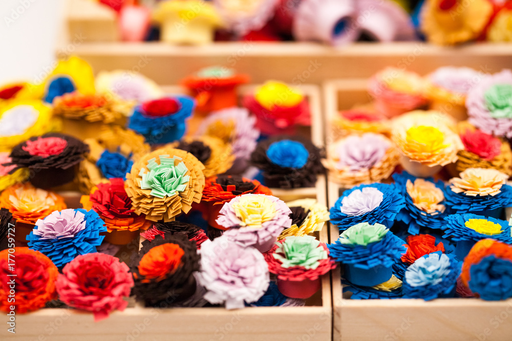 Small, colorful paper flowers made with quilling technique
