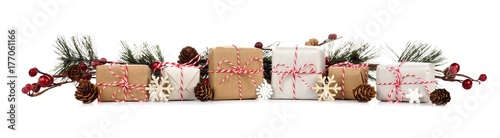 Christmas border with branches and rustic brown and white gift boxes isolated on a white background