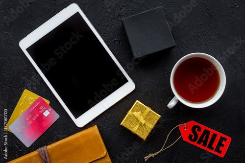 online payment for christmas present with credit card and tablet on black table background top view mockup