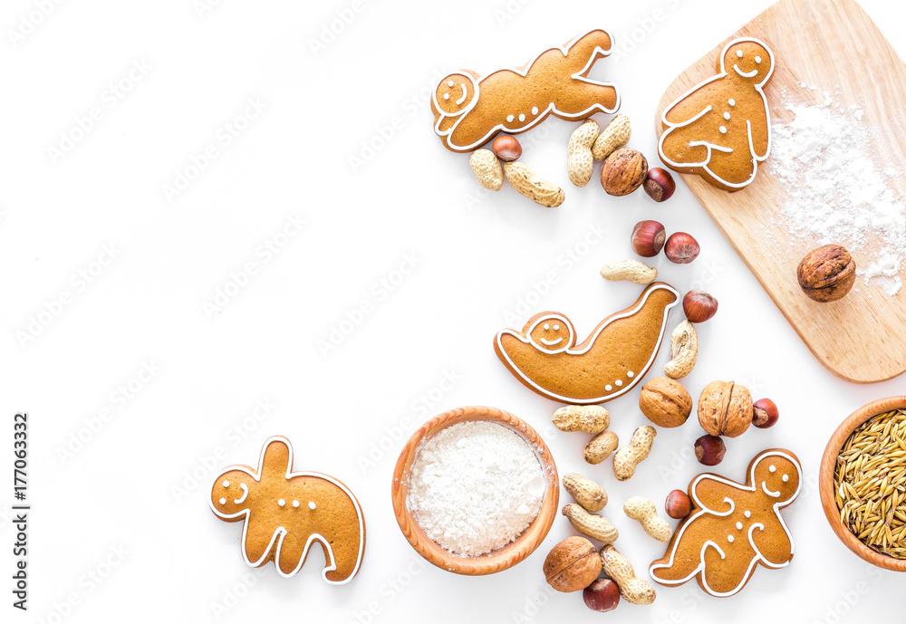 Healthy food for sportsman. Cookies in shape of yoga asanas near nuts on white background top view copyspace Healthy food for sportsman. Cookies in shape of yoga asanas near nuts on white background top view copyspace